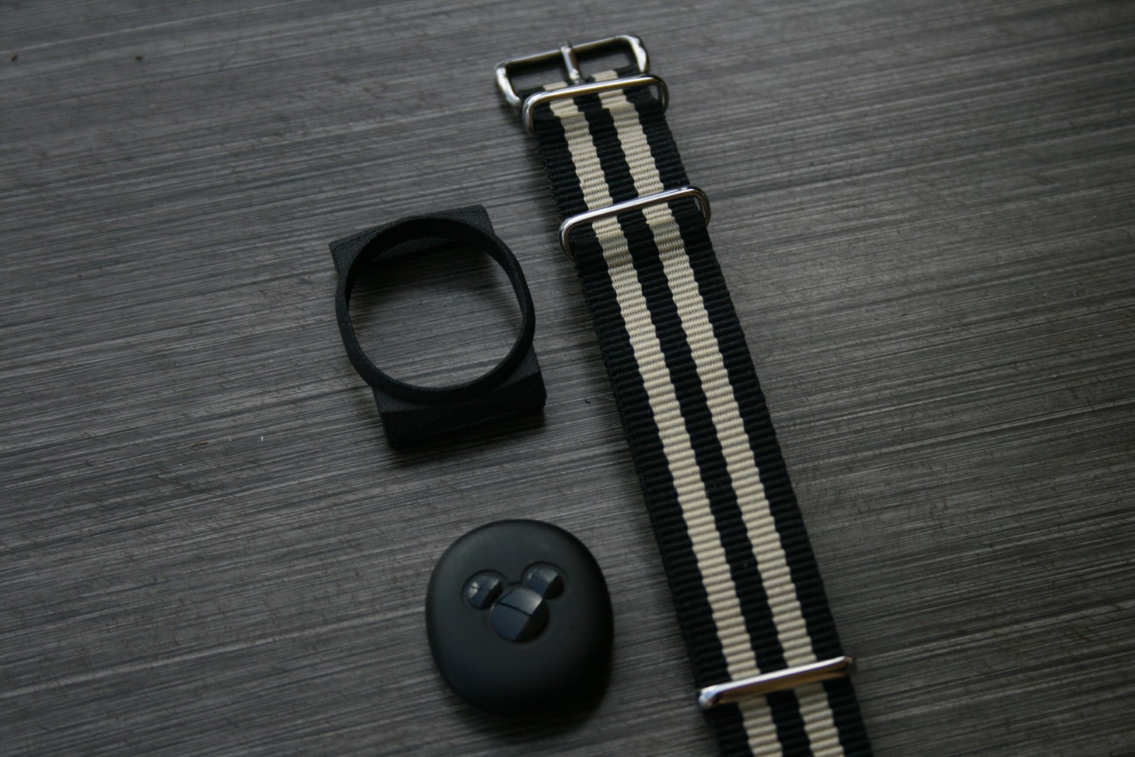 An exploded view of all the parts of the magic-band holder laid out on the table